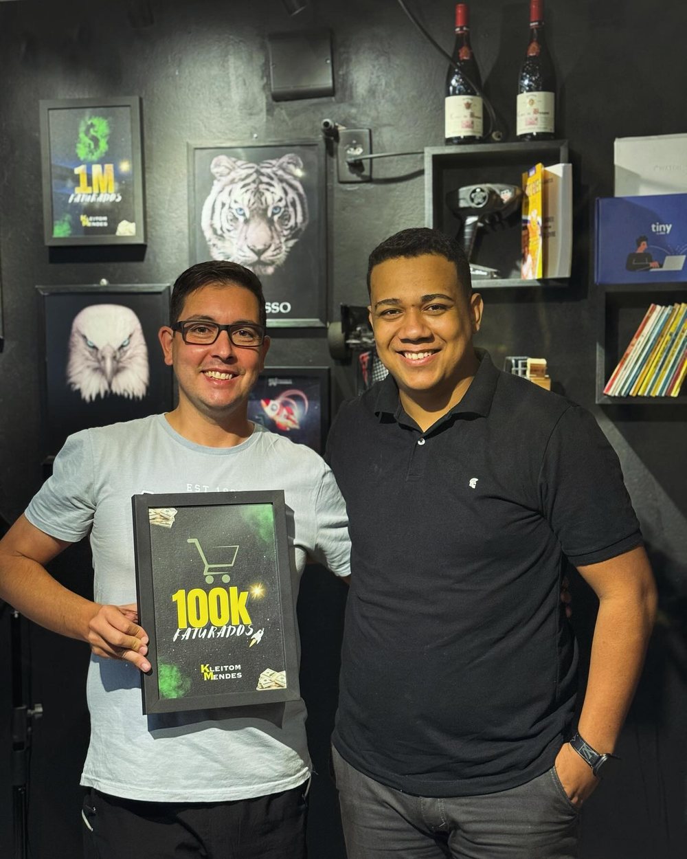 Kleitom Mendes ao lado do aluno Rodrigo, que recebe a placa de 100 mil reais faturados
